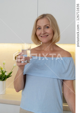 Healthy Lifestyle A Woman Delightfully Enjoying a Refreshing Beverage in a Modern and Stylish Kitchen Space Healthy Lifestyle A Woman Delightfully Enjoying a Refreshing Beverage in a Modern and Stylish Kitchen Space 126711636