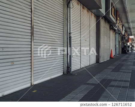 A shopping street with its shutters down 126711652