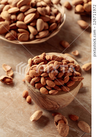 Almond nuts in a wooden bowl. Almond nuts in a wooden bowl. 126711972