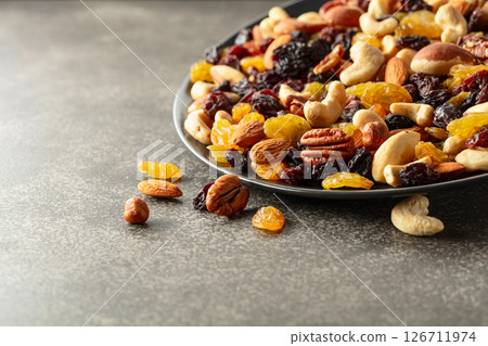 Mix of dried nuts and raisins on a rustic background. Mix of dried nuts and raisins on a rustic background. 126711974