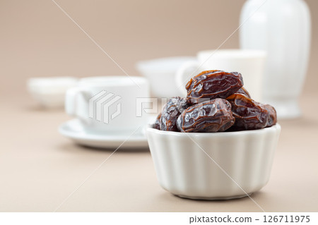 Dates in white dish on a beige background. Dates in white dish on a beige background. 126711975