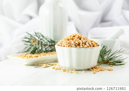 Peeled pine nuts on a white wooden table. 126711981