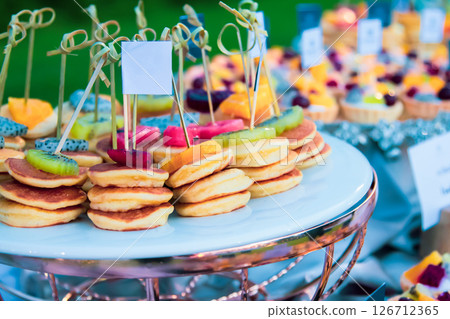 Dessert fruit pancakes at a wedding feast, food on a tray Dessert fruit pancakes at a wedding feast, food on a tray 126712365