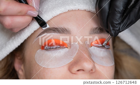 The process of professional lamination and dyeing of eyelashes and eyebrows in the salon. Four-handed procedure.  126712648