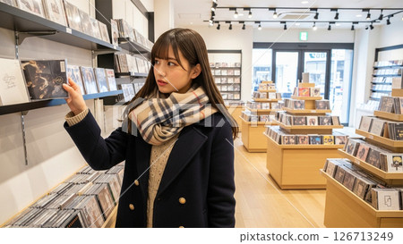 A student picking up a CD at a CD shop 126713249