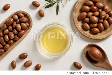 Rich argan oil surrounded by nuts on a clean, light background 126713542