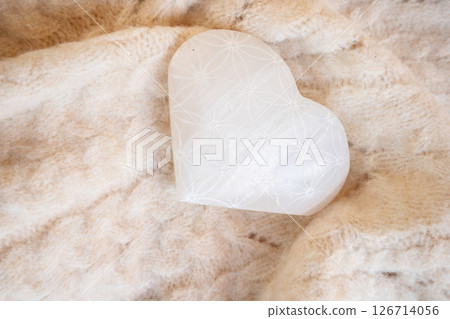 heart made of stone crystal with flower of life pattern on cozy blanket 126714056