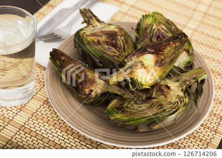 Cooked fried halves artichokes on brown plate Cooked fried halves artichokes on brown plate 126714206