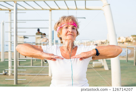 Mature woman doing exercises outdoors Mature woman doing exercises outdoors 126714207