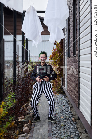 A Playful Clown Wearing Colorful and Striped Pants Cheerfully Poses by the Charming Pathway 126715583
