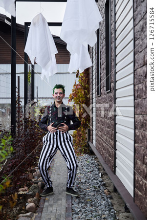 A whimsical clown adorned with ghost decorations is set in a vibrant outdoor environment A whimsical clown adorned with ghost decorations is set in a vibrant outdoor environment 126715584