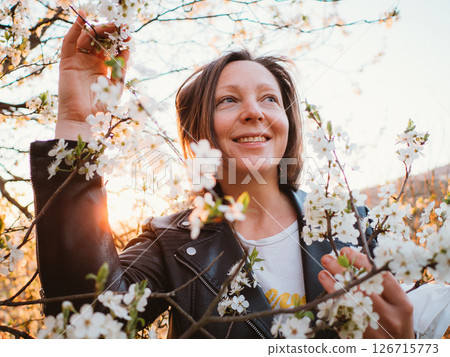 Woman Smiling Among Cherry Blossoms at Sunrise Woman Smiling Among Cherry Blossoms at Sunrise 126715773