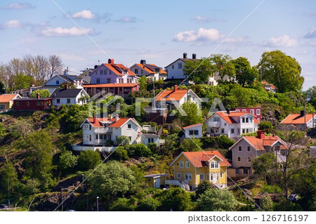 Picturesque colony of old small wooden historic houses on the Slottsberget mountain on the banks of the Gota alv river, Gothenburg, Sweden, sunny day 126716197