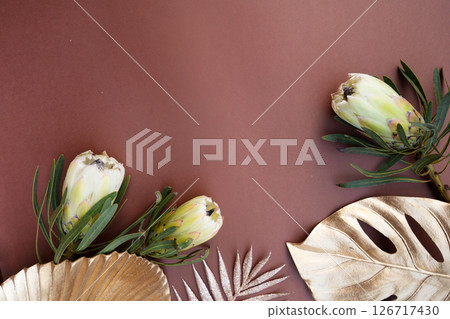 Tropical leaves and flowers over brown background, summer background with copy space Tropical leaves and flowers over brown background, summer background with copy space 126717430