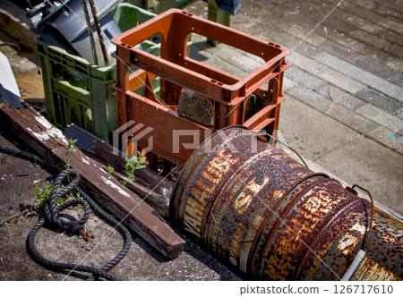 Rusty drums and crates of bottled beer are placed haphazardly. Rusty drums and crates of bottled beer are placed haphazardly. 126717610