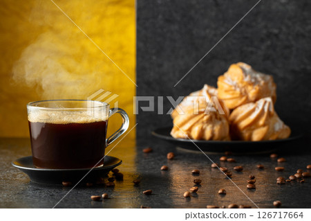 Black coffee in glass cup with coffee beans on a black stone table. Black coffee in glass cup with coffee beans on a black stone table. 126717664