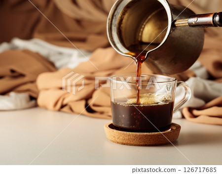 Pour the black coffee into a cup. 126717685