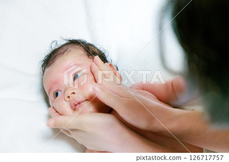 Mother applying lotion to her baby 126717757
