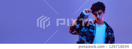 Banner. Teen boy lifting glasses with serious face, showing questioning, puzzled expression in neon light against gradient background with negative space Banner. Teen boy lifting glasses with serious face, showing questioning, puzzled expression in neon light against gradient background with negative space 126718034