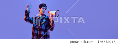 Banner. Teen boy raising hand while holding megaphone, expressing idea or opinion with calm confidence in neon light against gradient background. Banner. Teen boy raising hand while holding megaphone, expressing idea or opinion with calm confidence in neon light against gradient background. 126718047