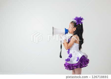 Cheerleader girl in a purple and white outfit using a megaphone. Studio shot on white background, showcasing her energetic, festive, and spirited vibe. A fun portrait of a young cheerleader. Cheerleader girl in a purple and white outfit using a megaphone. Studio shot on white background, showcasing her energetic, festive, and spirited vibe. A fun portrait of a young cheerleader. 126718691