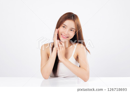 Skin glow and clear skin shine a beautiful Asian woman softly touches her face, showing confidence and calmness while representing natural skincare and wellness lifestyle isolated white background. 126718693