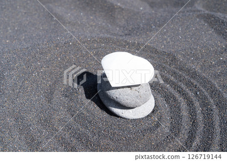 balancing stone with flower of life on black sand background balancing stone with flower of life on black sand background 126719144