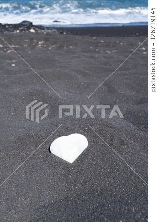 meditating on beach shore and holding crystal heart meditating on beach shore and holding crystal heart 126719145