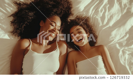 A Joyful Mother and Daughter Enjoy a Delightful and Warm Moment of Laughter Together While in Bed, Sharing Love A Joyful Mother and Daughter Enjoy a Delightful and Warm Moment of Laughter Together While in Bed, Sharing Love 126719332