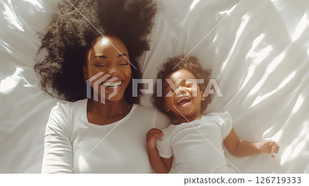 A Joyful Mother and Daughter Enjoy a Delightful and Warm Moment of Laughter Together While in Bed, Sharing Love 126719333