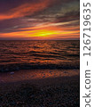 Picturesque seascape illuminated by golden rays of sun at sunset.  126719635