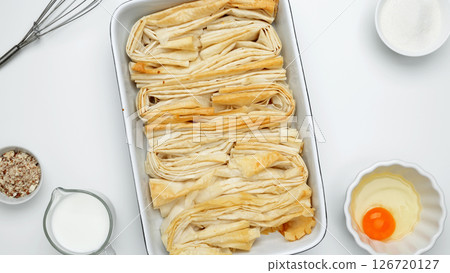 Ingredient egg, milk and sugar to make custard. Baked phyllo dough for Crinkle Cake 126720127