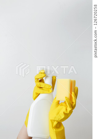 Household cleaning and hygiene concept. Womans hand in holds pink dishwashing sponge and cleaning product 126720258