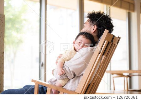Image of a dad holding a baby and putting him to sleep Image of a dad holding a baby and putting him to sleep 126720361