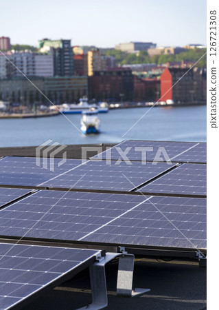 Solar panels on roof of apartment housing building with Gothenburg city center in background, Sweden, renewable green sustainable energy concept Solar panels on roof of apartment housing building with Gothenburg city center in background, Sweden, renewable green sustainable energy concept 126721308