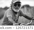 A senior man cycling outdoors, emphasizing an active and healthy lifestyle in old age 126721371