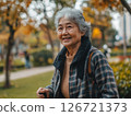 Senior woman walking with a cane in a park, highlighting mobility and independence in old age 126721373