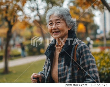 Senior woman walking with a cane in a park, highlighting mobility and independence in old age 126721373