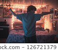 Teenager dancing in cozy room with string lights and posters creating a warm relaxed vibe 126721379