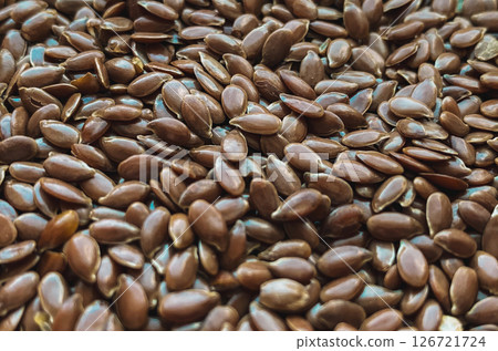 Macro close-up of raw brown flax seeds scattered in a natural pattern. Macro close-up of raw brown flax seeds scattered in a natural pattern. 126721724