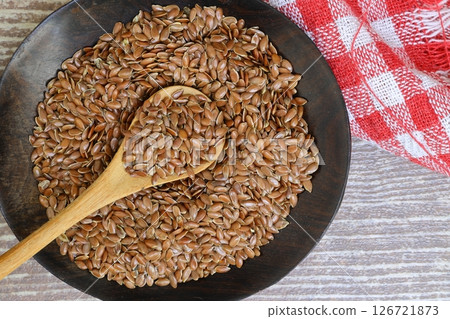 Flax seeds. Flaxseed powder in a wooden spoon. Standing on a Wooden background. Flax seeds. Flaxseed powder in a wooden spoon. Standing on a Wooden background. 126721873