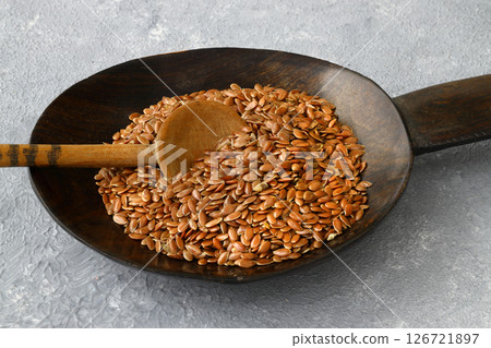 Flax seeds. Flaxseed powder in a wooden spoon. Standing on a Wooden background. Flax seeds. Flaxseed powder in a wooden spoon. Standing on a Wooden background. 126721897