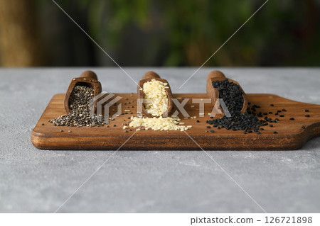 Wooden scoops with chia, black cumin and white sesame seeds close-up. Selective Focus. Wooden scoops with chia, black cumin and white sesame seeds close-up. Selective Focus. 126721898