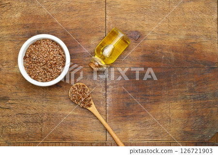 Flax seeds. Flaxseed powder in a wooden spoon. Standing on a Wooden background. 126721903