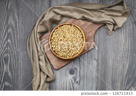 Green lentils in wooden bowl on wooden table background. Top view, copy space. Flat lay. 126721915