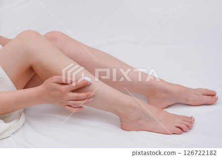 female hands with pedicure smear cream on feet 126722182