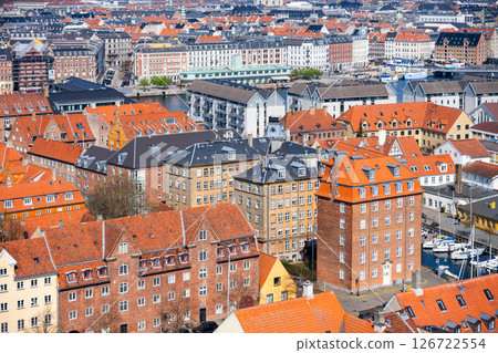 This aerial view captures the vibrant residential buildings of Copenhagen, showcasing their distinct architecture and red rooftops against a backdrop of canals. This aerial view captures the vibrant residential buildings of Copenhagen, showcasing their distinct architecture and red rooftops against a backdrop of canals. 126722554