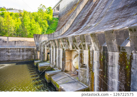 Constructed on the Vltava River, the Orlik Dam generates renewable energy while providing stunning views of nature. Surrounding greenery enhances the area's beauty during the day. 126722575