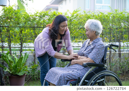 Caregiver help and care Asian senior woman patient sitting on wheelchair in park. 126722784