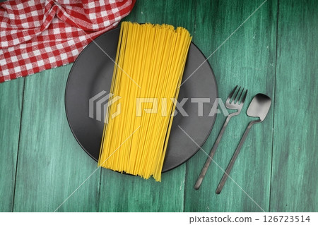 Flat lay of spaghetti for cooking italian pasta over black background. Top view of traditional italian cusine concept Flat lay of spaghetti for cooking italian pasta over black background. Top view of traditional italian cusine concept 126723514